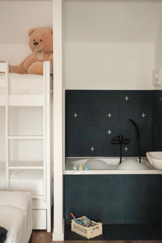 - un ours en peluche assis au-dessus d'un lit superposé dans l'établissement La Maison Près des Sables, à Plurien