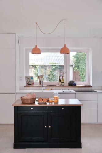 une cuisine avec un îlot noir au milieu dans l'établissement La Maison Près des Sables, à Plurien