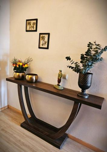 a wooden table with two vases and flowers on it at FeWo Cuba in Neue Scheune