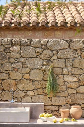 a stone wall with a bowl of fruit on a table at Liodentra in Kardamili