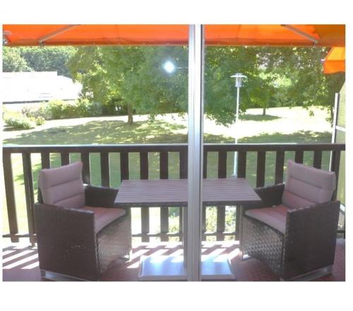 - une table et des chaises sur une terrasse couverte avec un parasol dans l'établissement Cambo1, à Cambo-les-Bains