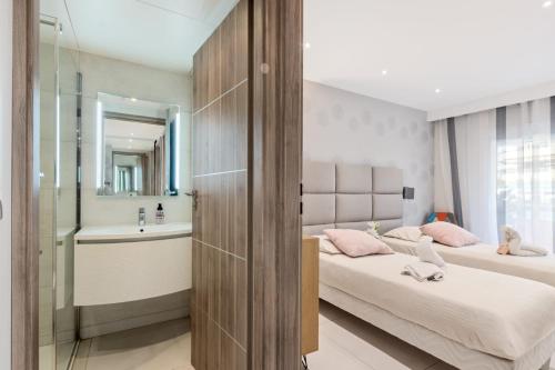 Cette chambre comprend 2 lits et une salle de bains avec lavabo. dans l'établissement Croisette Rental - Wonderfull 3 Bedrooms, à Cannes