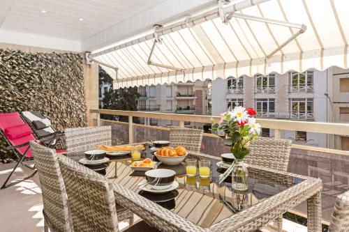 un patio avec une table et des chaises sur un balcon dans l'établissement Croisette Rental - Wonderfull 3 Bedrooms, à Cannes