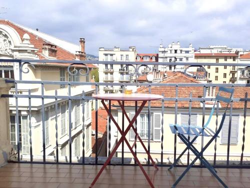 d'une table et de deux chaises sur un balcon avec des bâtiments dans l'établissement Hotel Solara, à Nice