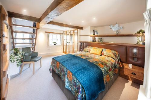 une chambre avec un lit, un bureau et une chaise dans l'établissement The Perfumery Cottage, à Bourton-on-the-Water