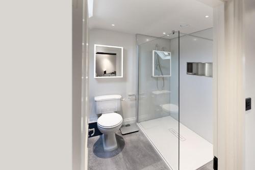 une salle de bain avec toilettes et douche en verre dans l'établissement The Perfumery Cottage, à Bourton-on-the-Water