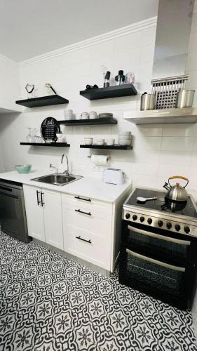 a kitchen with a stove and a sink at Casa da Marina de Angra in Angra do Heroísmo