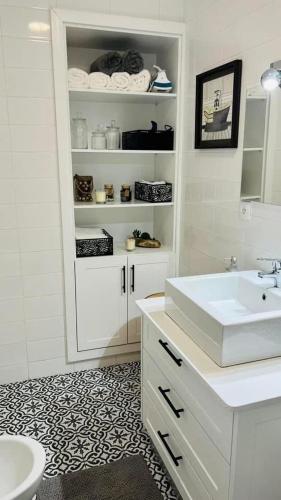 a bathroom with a sink and a white cabinet at Casa da Marina de Angra in Angra do Heroísmo