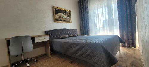 una camera da letto con un letto, una scrivania e una finestra di Apartament Bursztynowa Laguna a Ustronie Morskie