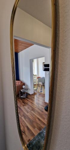 a mirror on a wall with a living room at MALA Modern Vienna Flair Apartment Donaustadt in Vienna