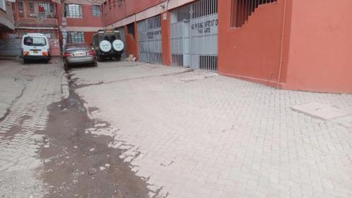 an empty parking lot next to a red building at Cutie homes_studio in Nairobi