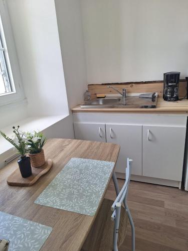 - une cuisine avec un évier et une table en bois dans l'établissement L'Instant Simplicité - Dormir Comme A La Maison, à Châteaubriant