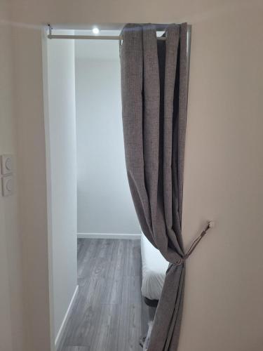 un rideau suspendu sur un mur dans une pièce dans l'établissement L'Instant Simplicité - Dormir Comme A La Maison, à Châteaubriant