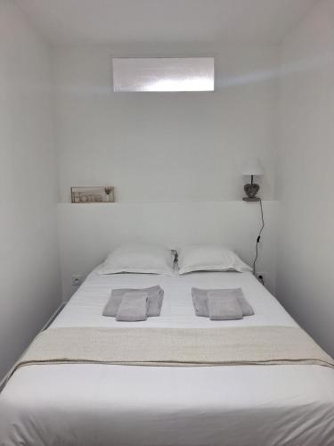 - un lit blanc dans une chambre blanche avec deux oreillers dans l'établissement L'Instant Simplicité - Dormir Comme A La Maison, à Châteaubriant