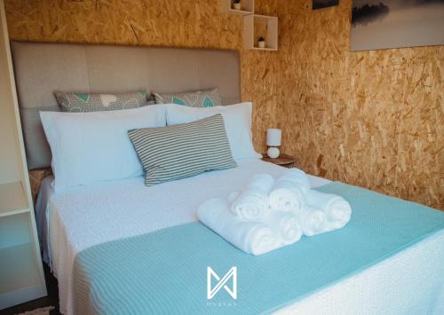 a bedroom with a bed with towels on it at MyStay - Bungalows in Quinta dos Sobrais in Valença