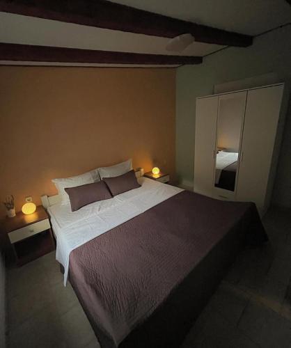 a bedroom with a large bed and two lamps at Kolonjicha Dvori in Ivan Dolac