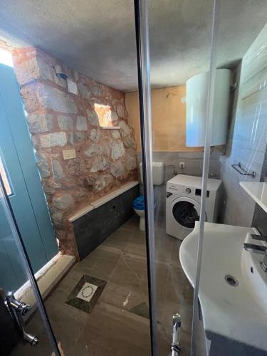 a bathroom with a sink and a washing machine at Kolonjicha Dvori in Ivan Dolac