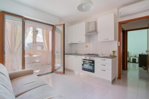 a kitchen with white cabinets and a stove top oven at Casa Suite Himalaya Estate in Sardegna Vicino al Mare e Aeroporto Wi-Fi & Parcheggio in Selargius