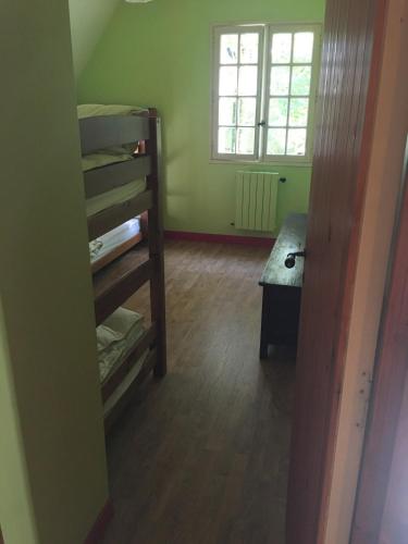 une chambre avec un lit superposé et une fenêtre dans l'établissement Morlaix - Maison au milieu des bois, à Plourin