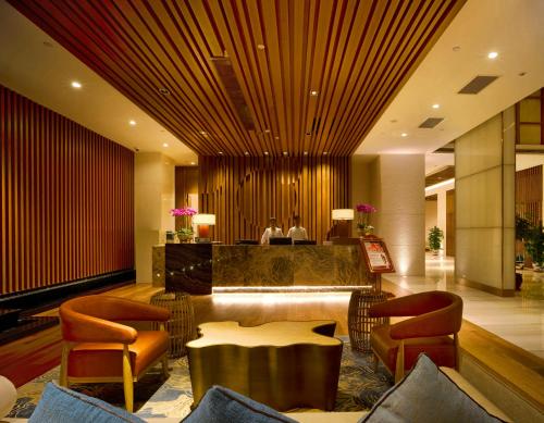 a lobby of a hotel with a table and chairs at Harman Resort Hotel Sanya in Sanya