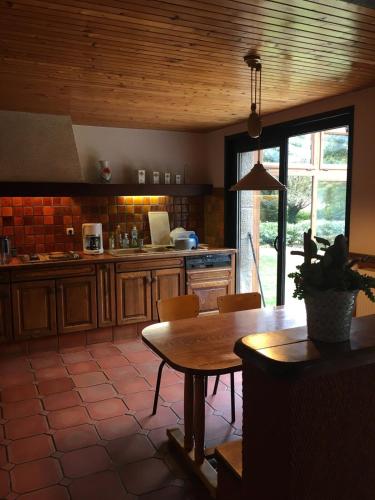 - une cuisine avec une table et un comptoir dans l'établissement Morlaix - Maison au milieu des bois, à Plourin