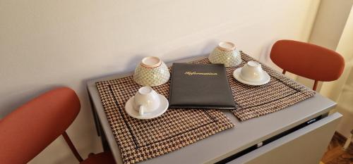 a table with two chairs and a book on it at MALA Modern Vienna Flair Apartment Donaustadt in Vienna
