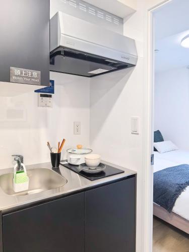 a kitchen with a sink and a stove at Poka Stay Kamata 暖居蒲田 in Tokyo