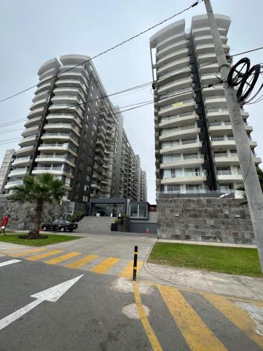 two tall apartment buildings in a parking lot at Panoramic Elegante departamento in Lima