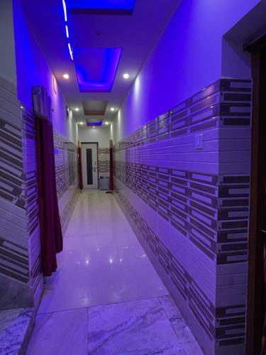 a long aisle with purple lights in a building at Hotel Maa Durga Guest House Near Beach in Digha