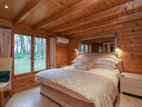 a bedroom with a bed in a log cabin at Woodpeckers in Cullompton