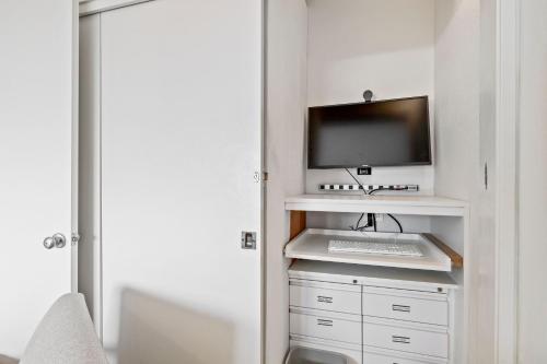 a room with a desk with a computer on a shelf at 7 Pelican! Sweeping Ocean Views & Front Row Beach Access in Watsonville