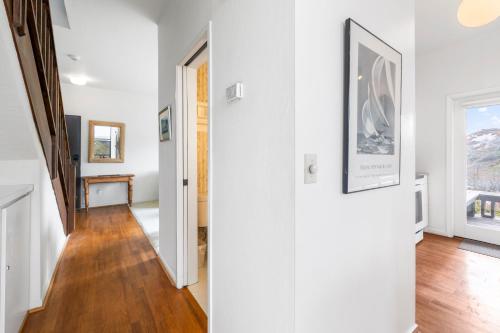 a hallway of a home with white walls and wooden floors at 7 Pelican! Sweeping Ocean Views & Front Row Beach Access in Watsonville