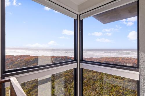 a room with windows looking out at the ocean at 7 Pelican! Sweeping Ocean Views & Front Row Beach Access in Watsonville