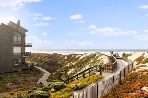 a house on the beach next to the ocean at 7 Pelican! Sweeping Ocean Views & Front Row Beach Access in Watsonville