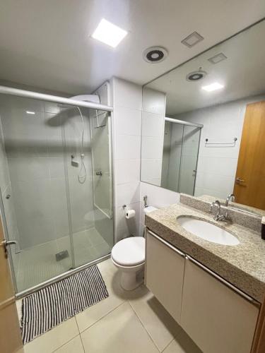 a bathroom with a shower and a toilet and a sink at Via Brisa Apartment in Brasília