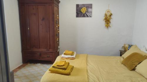 a bedroom with a bed with two towels on it at Blue&YellowHouse in Alcoutim