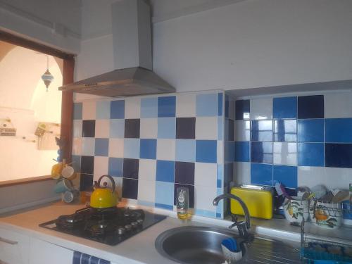 a kitchen with a sink and blue and white tiles at Blue&YellowHouse in Alcoutim