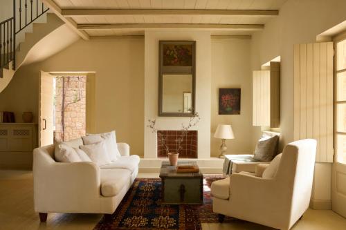 a living room with two white chairs and a table at Liodentra in Kardamili