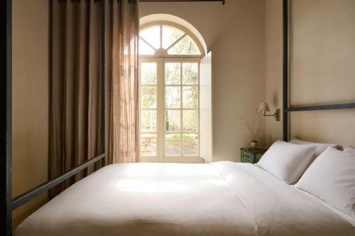 a bedroom with a large white bed and a window at Liodentra in Kardamili