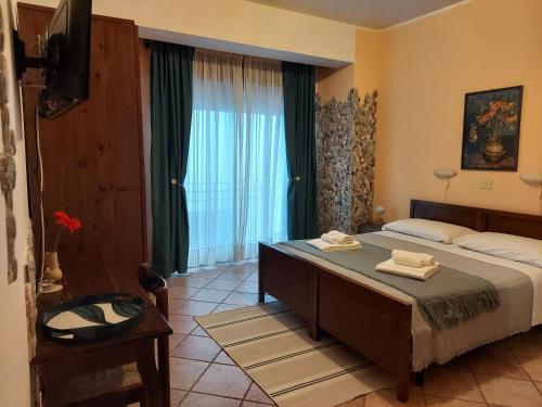 a bedroom with a bed and a large window at Sole Mare B&B in Giardini Naxos
