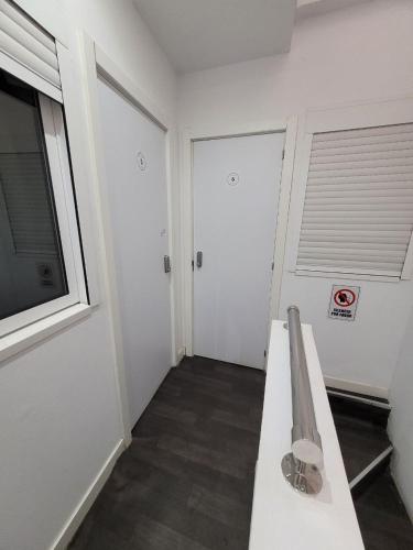 a white room with a bench and a window at AYZ Frailes - Auto check-in property in Málaga