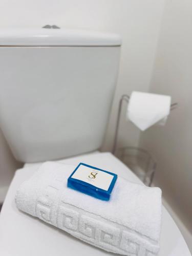 a white bed with a blue box on a pile of towels at The Rural Woodside Cabin by MaisonPro in Stroud