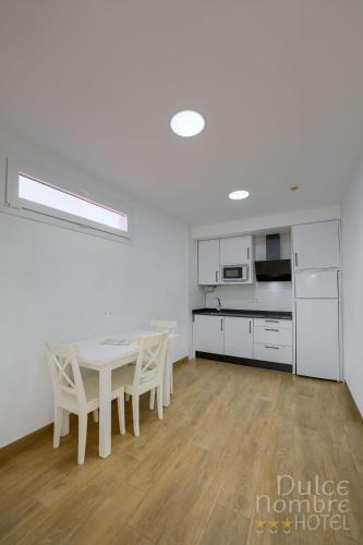 a kitchen and dining room with a table and chairs at Dulce Nombre Hotel - Apartamentos in Tarifa
