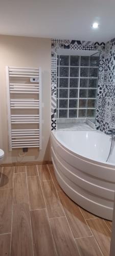 une baignoire blanche dans une salle de bain avec une fenêtre dans l'établissement Gîte de la Salamandre, à Saint-Privat-de-Vallongue