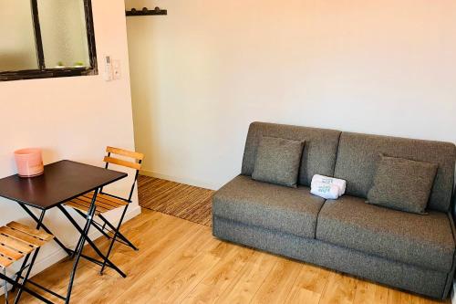 un salon avec un canapé et une table dans l'établissement Louisa - Studio AC Close to the sea - by TGB, à Ajaccio