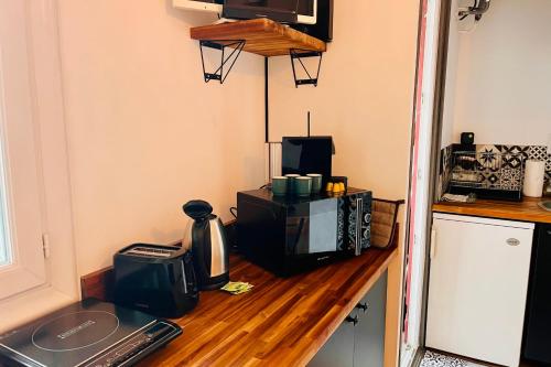 - un comptoir de cuisine avec un four micro-ondes et une télévision dans l'établissement Louisa - Studio AC Close to the sea - by TGB, à Ajaccio