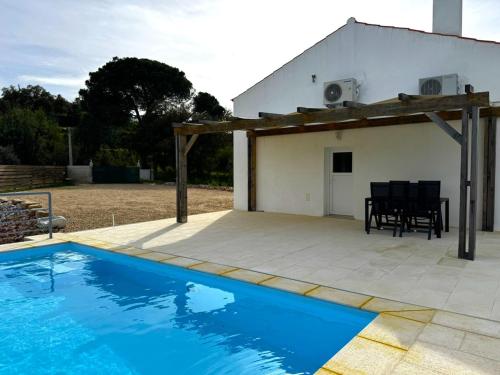 a patio with a swimming pool and a house at Refúgio sobre a paisagem alentejana in Mora