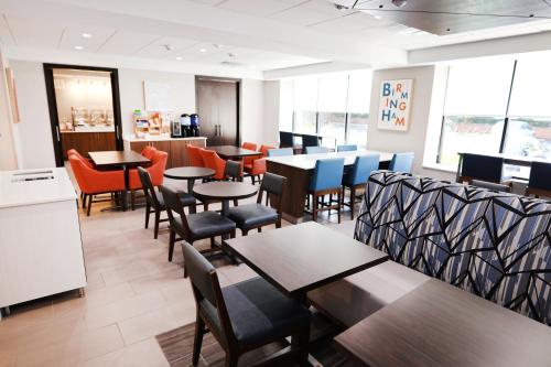 a dining room with tables and chairs in a restaurant at Holiday Inn Express Detroit-Birmingham by IHG in Birmingham