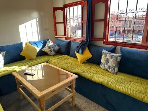 a living room with a blue couch and a table at Residence Dallas Warzazate in Ouarzazate