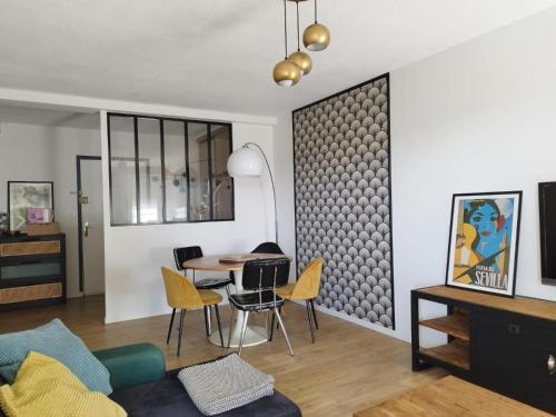 un salon avec une table et des chaises jaunes dans l'établissement La Sevillana - 3 Bedrooms - Cute Terrace - 2 Parkings, à Toulouse